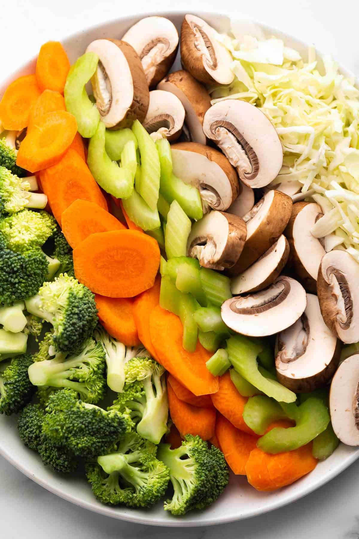 Prepared broccoli florets, carrot, celery, mushrooms, and cabbage for making vegetable teriyaki.