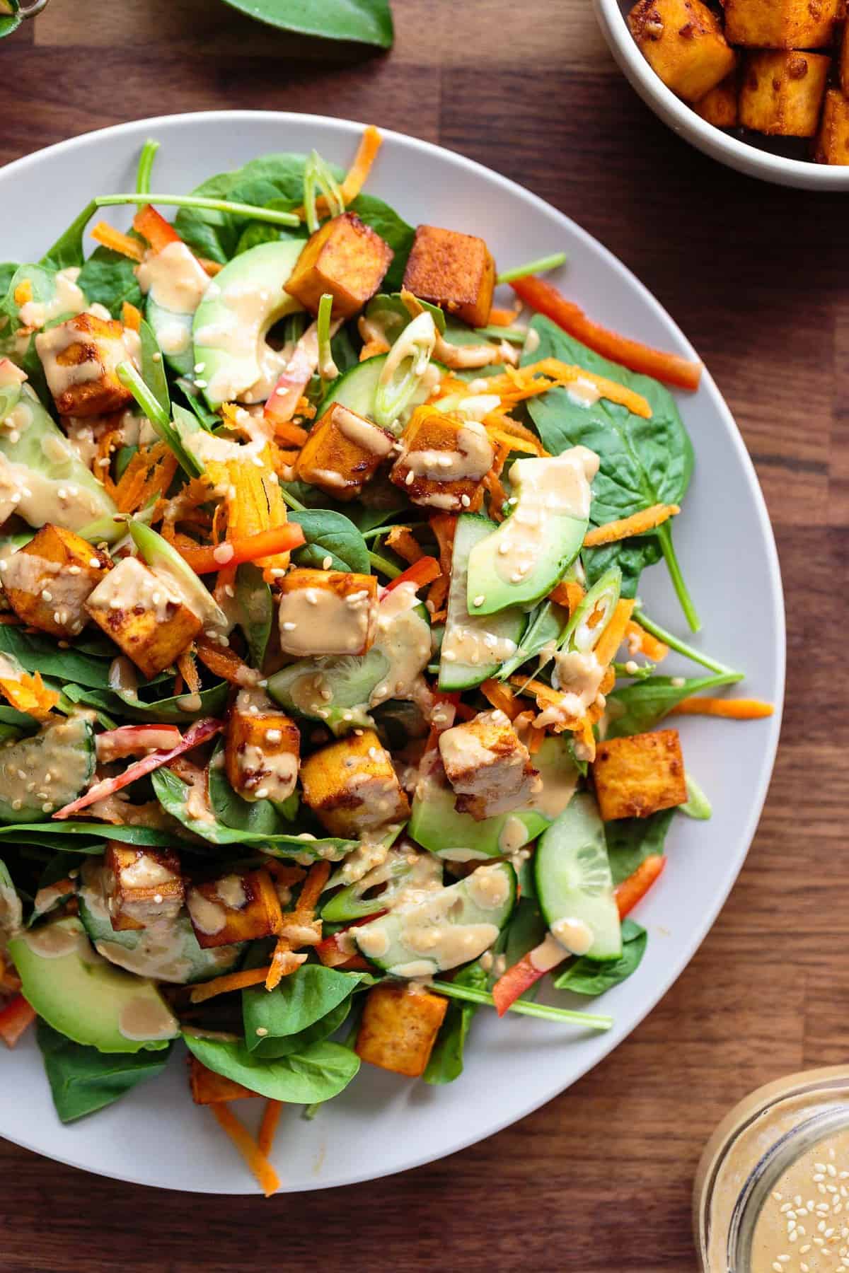 Salad of baby spinach, marinated tofu, avocado, carrot, cucumber, red bell pepper, green onion with a creamy toasted sesame and soy dressing.