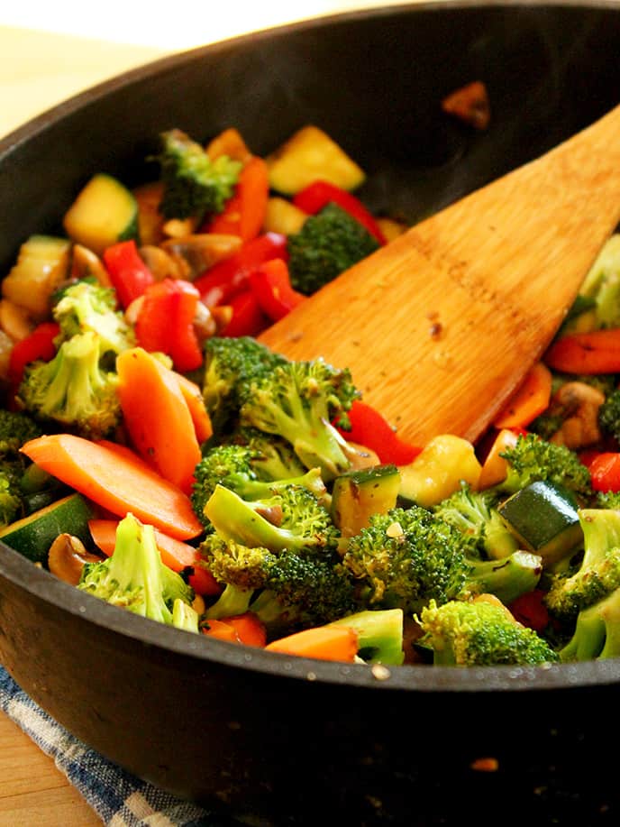 Stir-frying vegetables to make Teriyaki Peanut Tofu with Stir-Fried Veggies & Brown Rice.