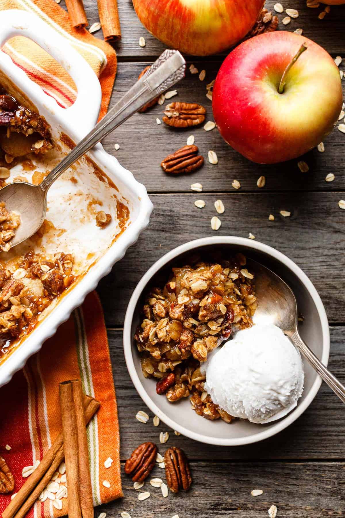 A bowl of vegan apple crisp served with a scoop of dairy-free vanilla ice cream.