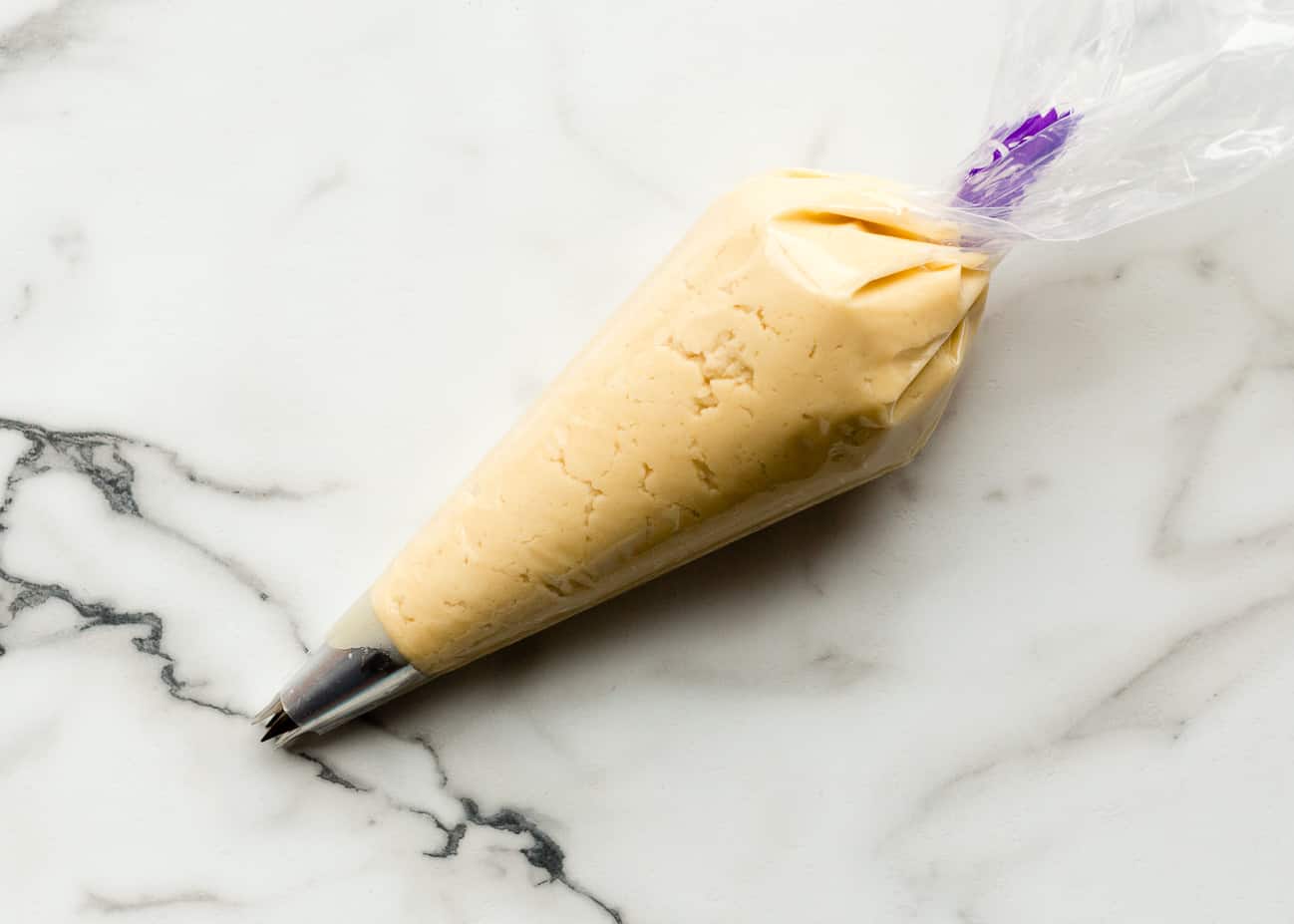 Vegan butter cookie dough in a piping bag with a large star tip.