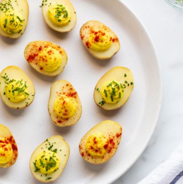 Vegan deviled egg potatoes garnished with paprika and fresh chives.