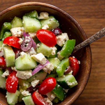 A wooden bowl of vegan Greek salad.