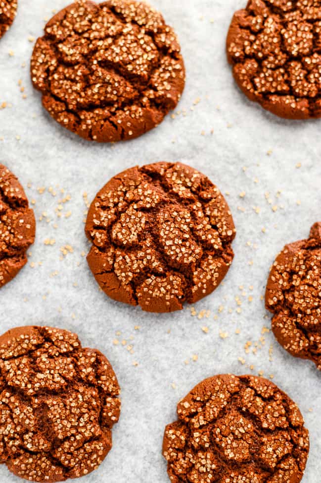 Freshly baked vegan molasses cookies on parchment paper.